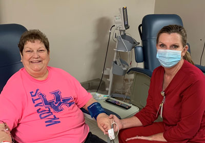 Nurse (female) and Patient (female) smiling. Patient is having an infusion therapy