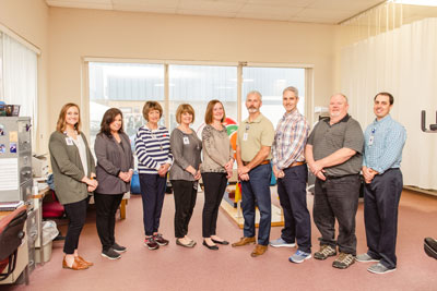 Picture of Therapists, lined up in a single row, smiling.